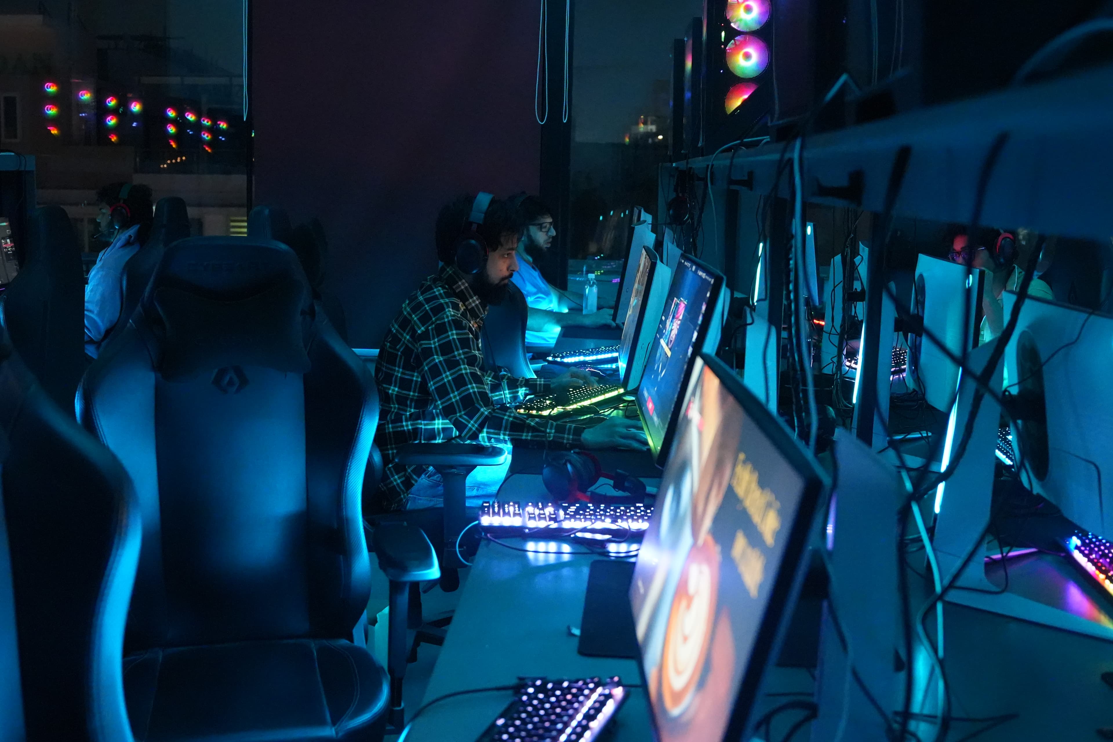 Players locked in on the blue-lit gaming floor at Gamers Guild